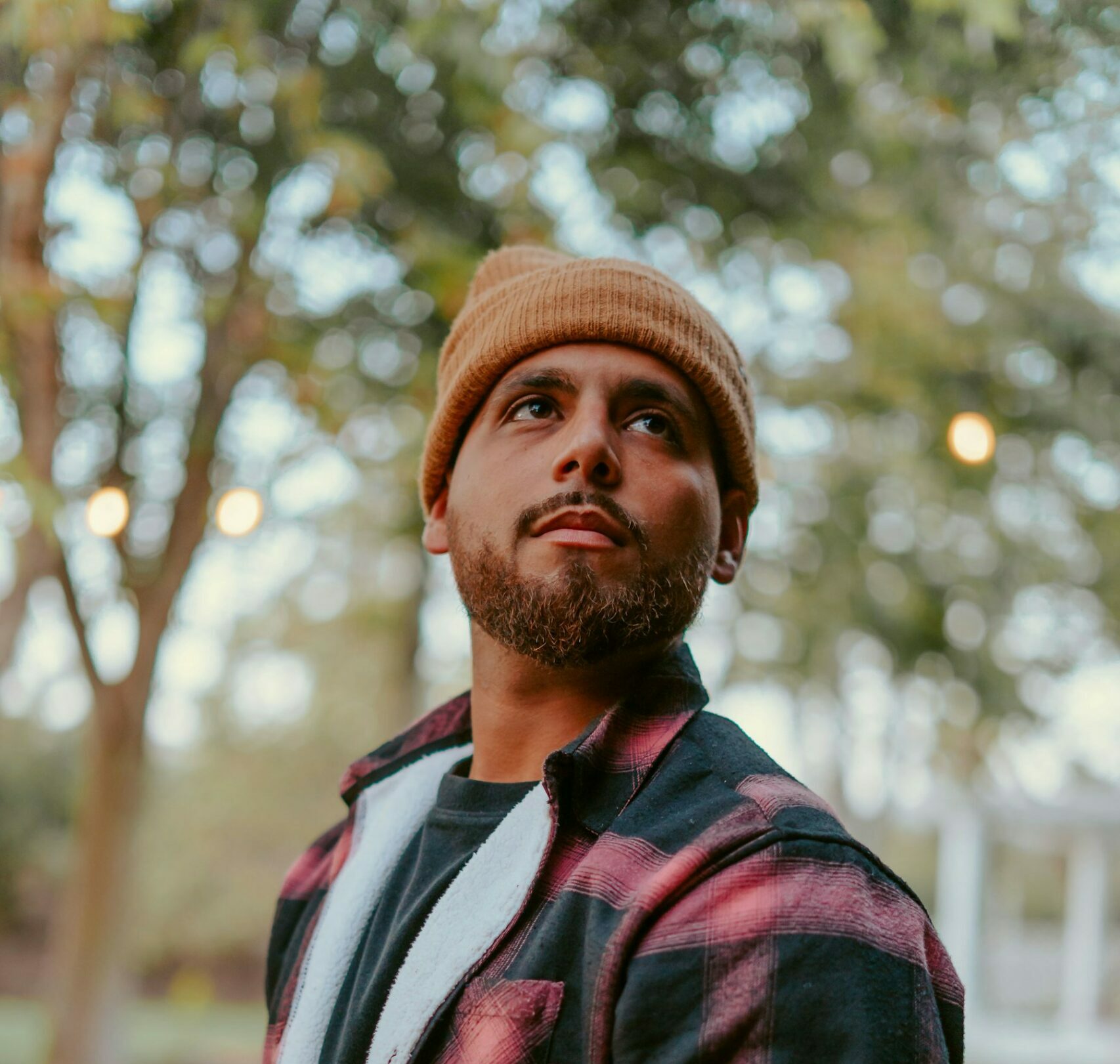 a man with a beard wearing a red and black flannel shirt